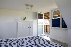 Una habitación blanca con una cama y una ventana. en Ferienhaus Annika in Schillig-Horumersiel mit 8 modernen Wohnungen, en Schillig