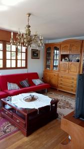sala de estar con sofá rojo y mesa en Casa Tirador, en San Martín del Mar