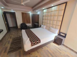 a bedroom with a large white bed with a large headboard at HOTEL RAHI. in Rānchī