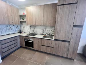 a kitchen with wooden cabinets and a sink at Kristall Lago Residence in Desenzano del Garda