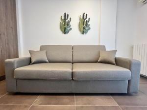 a couch in a living room with cactuses on the wall at Kristall Lago Residence in Desenzano del Garda