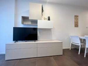 a living room with a tv on a white cabinet at Kristall Lago Residence in Desenzano del Garda