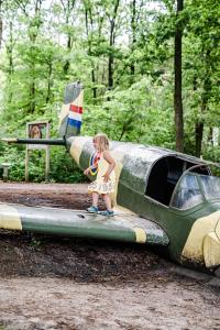 una niñita parada al final de un avión en TinyParks Forest Cabins, en Hoogersmilde