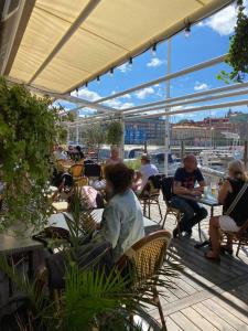 a group of people sitting at tables in a restaurant at Husbåten Vega 2 Göteborg City in Gothenburg