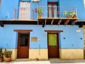 a blue building with two doors and a balcony at Marnabianca Apartment in Realmonte