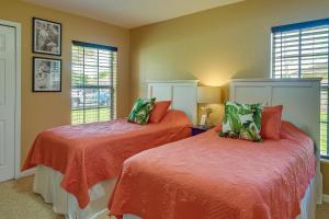 um quarto com 2 camas com lençóis laranja e janelas em Clewiston Bluegill Home Rental with Fishing Pond! em Clewiston