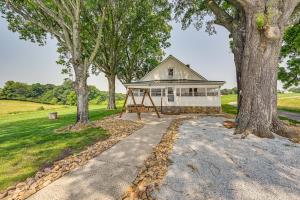 ein Haus im Wald mit Schaukel und Bäumen in der Unterkunft Dobson Farmhouse with Scenic Porch - Near Vineyards! in Dobson