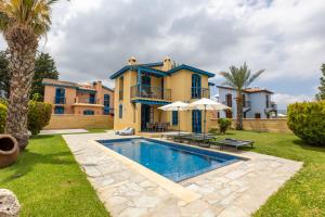 a villa with a swimming pool in front of a house at The Olympians Villas in Polis Chrysochous