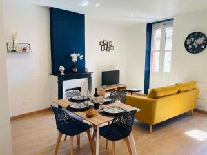 a living room with a table and a yellow couch at L’orchidée in Caussade