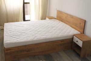 Апартаменты на Сабуртало في تبليسي: سرير في غرفة مع إطار سرير خشبي