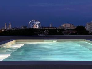 a large swimming pool with a ferris wheel in the background at Ulisse Palace in Lido di Jesolo