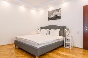 a bedroom with a large bed with white sheets at Cedrus Boutique in Braşov