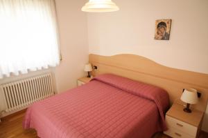 een slaapkamer met een bed met een rode deken bij Sole&Luna Apartment in Trento