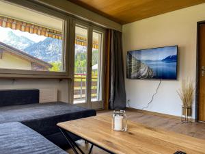 a room with a bed and a table and a large window at Swiss Alps Lodge in Kandersteg