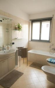 een badkamer met een bad, een wastafel en een bad bij Sole&Luna Apartment in Trento