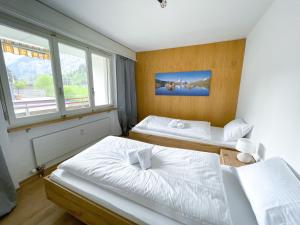 1 dormitorio con 2 camas y ventana en Swiss Alps Lodge en Kandersteg