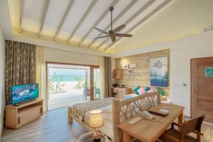 a bedroom with a bed and a television and a table at You & Me Maldives - Adults Only - Premium All-Inclusive in Raa Atoll