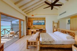 a bedroom with a large bed and a balcony at You & Me Maldives - Adults Only - Premium All-Inclusive in Raa Atoll
