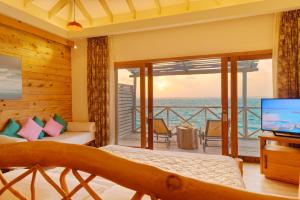 a bedroom with a view of the ocean at You & Me Maldives - Adults Only - Premium All-Inclusive in Raa Atoll
