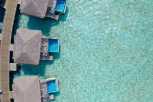 an aerial view of a pool of water with houses at You & Me Maldives - Adults Only - Premium All-Inclusive in Raa Atoll