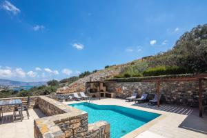 een villa met een zwembad en een patio bij Maris Villas in Elounda