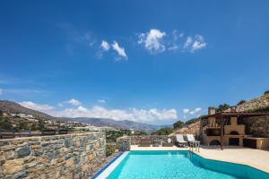 een villa met een zwembad en een huis bij Maris Villas in Elounda