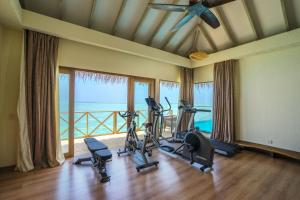 a gym with exercise equipment in a room with a balcony at You & Me Maldives - Adults Only - Premium All-Inclusive in Raa Atoll
