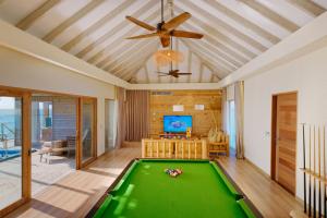 a pool table in a living room with a ceiling fan at You & Me Maldives - Adults Only - Premium All-Inclusive in Raa Atoll