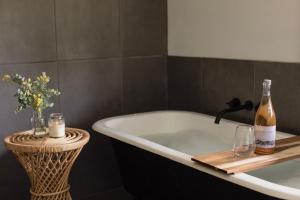 a bath tub with two bottles of wine and candles at Happy Nomad in St Helens