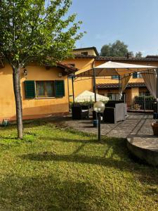 a house with a tree in front of a yard at Charming Townhouse with Garden in Impruneta