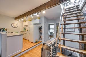 a kitchen with a staircase leading to a loft at Cozy Boston Vacation Rental with Rooftop Deck! in Boston