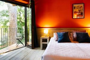 a bedroom with a bed and a balcony at ACCADEMIA VINE LODGE in Capriva del Friuli