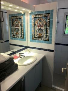 une salle de bain avec un lavabo et un miroir dans l'établissement Villa Ancône, à Calcatoggio