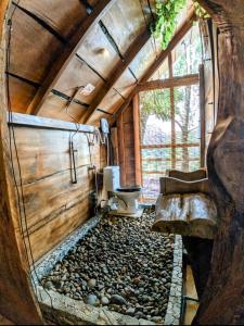Un baño pequeño con inodoro y rocas. en Kale Cottage Belihuloya, en Belihuloya