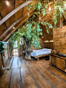 un dormitorio con una cama y un árbol dentro en Kale Cottage Belihuloya, en Belihuloya