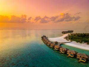 an aerial view of a resort on the beach at sunset at You & Me Maldives - Adults Only - Premium All-Inclusive in Raa Atoll