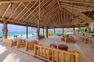 a restaurant on the beach with tables and chairs at You & Me Maldives - Adults Only - Premium All-Inclusive in Raa Atoll