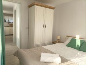 una camera con un letto con una coperta verde e bianca di Tiny Village Mamaia Nord - House 4 a Mamaia Nord - Năvodari