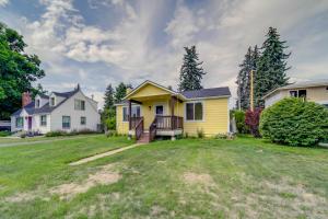 une maison jaune avec terrasse couverte dans une cour dans l'établissement Pet-Friendly Idaho Retreat Near Beaches and Hiking!, à Coeur d'Alene