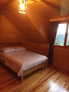 um quarto com uma cama num quarto de madeira em Gürgen House em Cayeli