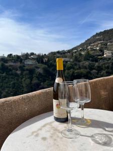 una bottiglia di vino e due bicchieri di vino su un tavolo di Cosy and Comfy Studio with Sea View a Tourrettes-sur-Loup