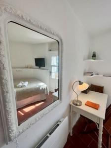 specchio in una stanza con letto e tavolo di Cosy and Comfy Studio with Sea View a Tourrettes-sur-Loup