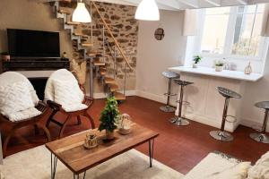 - un salon avec un escalier, des chaises et une table dans l'établissement Charmant duplex en centre-ville, au Mans