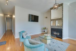 a living room with a fireplace and blue chairs at Chicago Condo Laptop Workspace, 6 Mi to Downtown! in Chicago