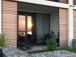 eine Terrasse mit einem Tisch und Stühlen auf einem Haus in der Unterkunft Apartment Zwenkauer See in Zwenkau