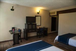 a hotel room with two beds and a television at Mision De Los Angeles in Oaxaca City