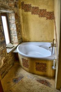 a bath tub in a bathroom with a window at Althea Archontika Tis Androu in Batsi +100 photos