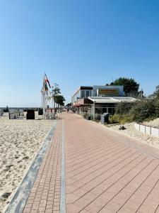 a walkway on the beach with a building in the background at Ferienwohnung "Dahme & Strandkorb" in Dahme
