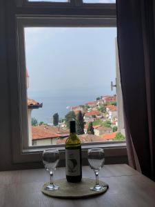 una botella de vino sentada en una mesa con dos copas en Apartments Misa, en Ohrid