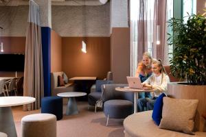 two women sitting at a table with a laptop at ibis budget Gent Centrum Dampoort in Ghent